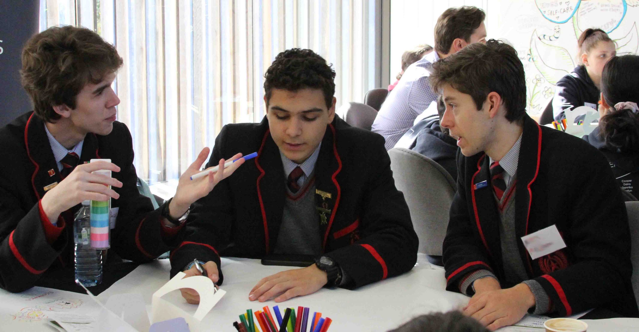 Photo of three boys discussing a Charter launch activity
